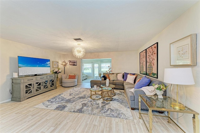 1622 Stafford Ln Unit 1205, Sarasota, FL 34232 - living room featuring visible vents, baseboards, wood finished floors, and a notable chandelier