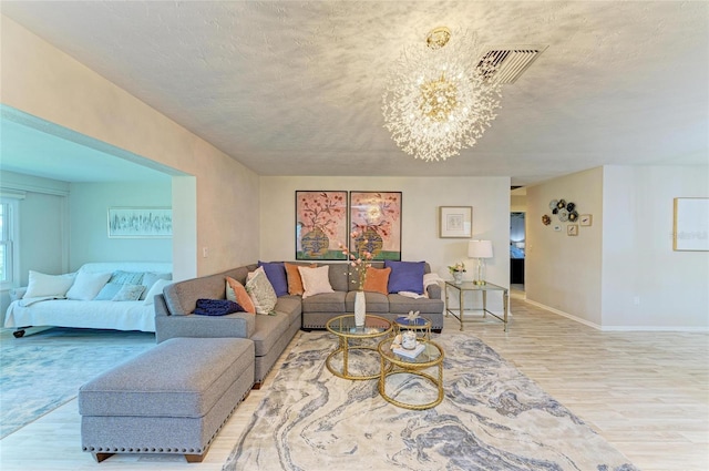 1622 Stafford Ln Unit 1205, Sarasota, FL 34232 - living room with a textured ceiling, wood finished floors, an inviting chandelier, baseboards, and visible vents
