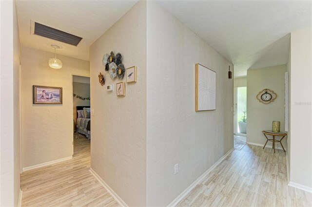 1622 Stafford Ln Unit 1205, Sarasota, FL 34232 - hall featuring a textured wall, baseboards, visible vents, and light wood-style floors