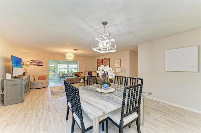 1622 Stafford Ln Unit 1205, Sarasota, FL 34232 - dining room featuring a chandelier, light wood-style flooring, and baseboards