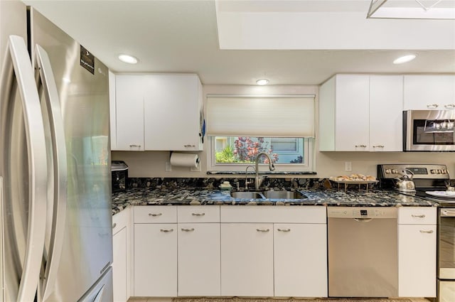1622 Stafford Ln Unit 1205, Sarasota, FL 34232 - kitchen with white cabinets, dark stone countertops, stainless steel appliances, and a sink