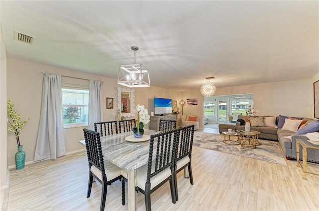 1622 Stafford Ln Unit 1205, Sarasota, FL 34232 - dining room featuring a chandelier, light wood-style flooring, visible vents, and a healthy amount of sunlight