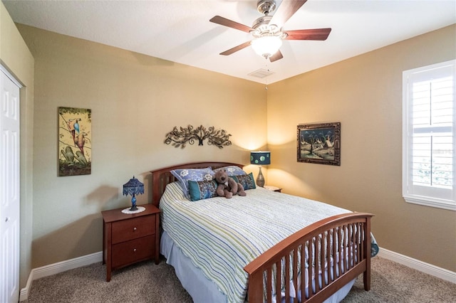 carpeted bedroom with a ceiling fan, baseboards, visible vents, and multiple windows