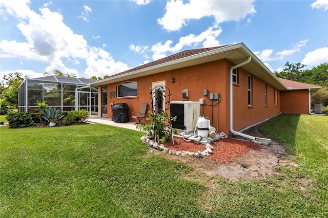 rear view of house featuring a patio, a lanai, stucco siding, and a yard