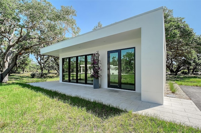 7200 Chameleon Way, Sarasota, FL 34241 - doorway to property with stucco siding and a lawn