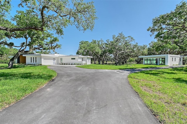7200 Chameleon Way, Sarasota, FL 34241 - mid-century inspired home with an attached garage, asphalt driveway, a front lawn, and stucco siding