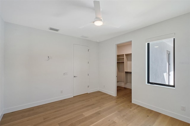 7200 Chameleon Way, Sarasota, FL 34241 - unfurnished bedroom with light wood finished floors, a spacious closet, ceiling fan, and a closet