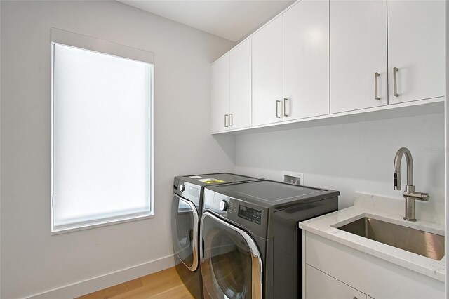 7200 Chameleon Way, Sarasota, FL 34241 - laundry area featuring washing machine and dryer, cabinet space, and light wood finished floors