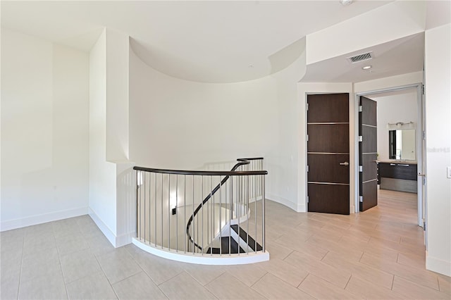221 Cosmopolitan Ct, Sarasota, FL 34236 - hallway with baseboards, visible vents, and an upstairs landing