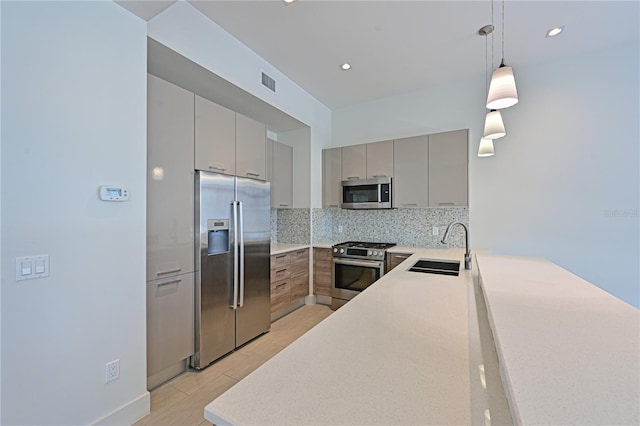 221 Cosmopolitan Ct, Sarasota, FL 34236 - kitchen featuring stainless steel appliances, a sink, visible vents, decorative backsplash, and gray cabinets