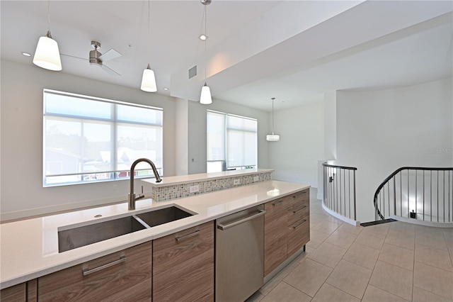 221 Cosmopolitan Ct, Sarasota, FL 34236 - kitchen featuring light countertops, a sink, brown cabinets, dishwasher, and decorative light fixtures