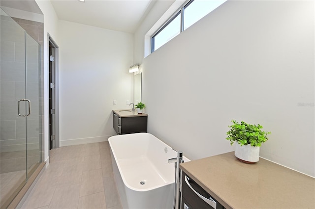 221 Cosmopolitan Ct, Sarasota, FL 34236 - bathroom featuring a soaking tub, baseboards, vanity, and a stall shower