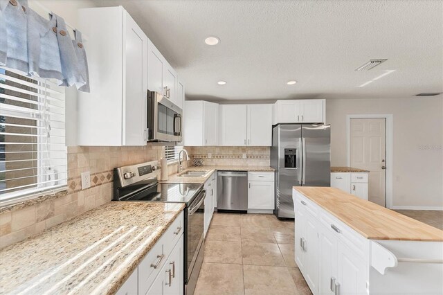 2151 Upton Ave, Sarasota, FL 34232 - kitchen with a sink, backsplash, stainless steel appliances, and visible vents