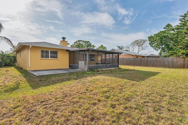 2151 Upton Ave, Sarasota, FL 34232 - rear view of house with fence, a sunroom, a chimney, a lawn, and a patio