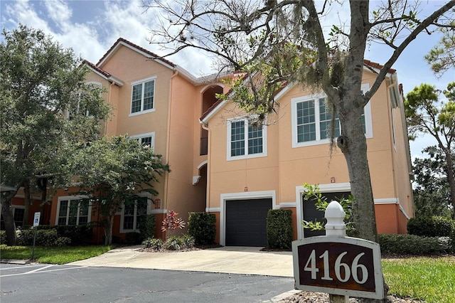4166 Central Sarasota Pkwy Unit 535, Sarasota, FL 34238 - view of front of property featuring an attached garage, driveway, a tiled roof, and stucco siding