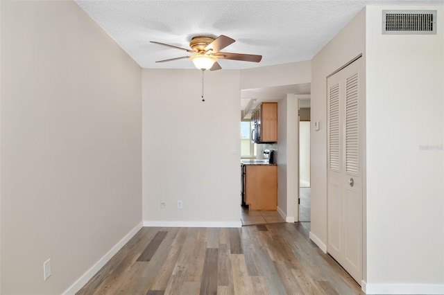 4885 1st St NE Unit 308, Saint Petersburg, FL 33703 - interior space with light wood-style flooring, a textured ceiling, a ceiling fan, and visible vents