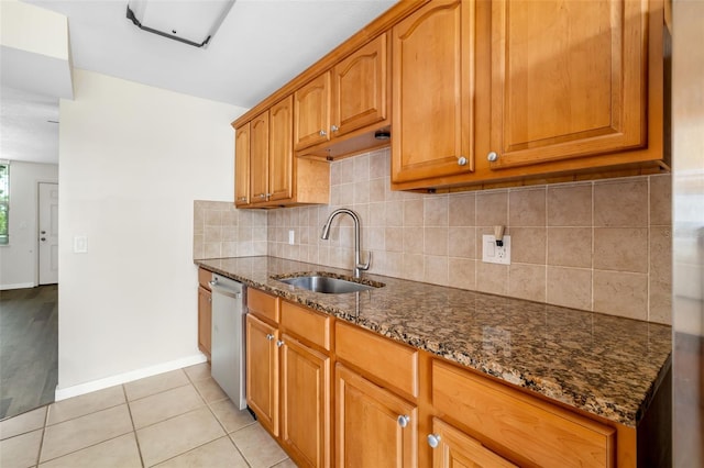 4885 1st St NE Unit 308, Saint Petersburg, FL 33703 - kitchen featuring dark stone countertops, light tile patterned floors, a sink, stainless steel dishwasher, and decorative backsplash