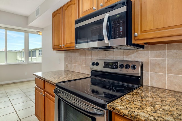 4885 1st St NE Unit 308, Saint Petersburg, FL 33703 - kitchen featuring stone counters, visible vents, baseboards, and appliances with stainless steel finishes
