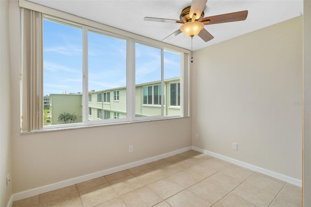 4885 1st St NE Unit 308, Saint Petersburg, FL 33703 - spare room featuring a healthy amount of sunlight, baseboards, and a ceiling fan