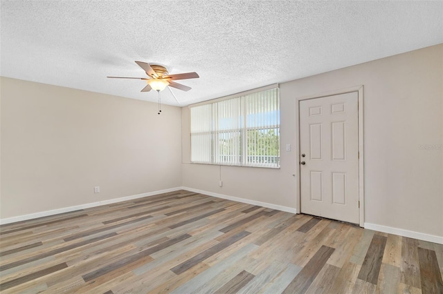 4885 1st St NE Unit 308, Saint Petersburg, FL 33703 - unfurnished room with a textured ceiling, wood finished floors, baseboards, and a ceiling fan