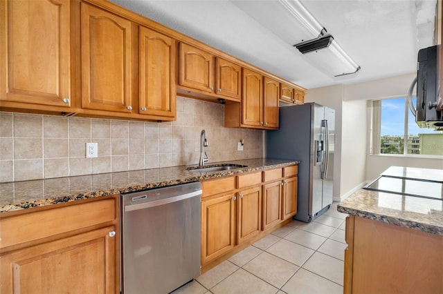 4885 1st St NE Unit 308, Saint Petersburg, FL 33703 - kitchen featuring appliances with stainless steel finishes, dark stone countertops, light tile patterned flooring, decorative backsplash, and a sink