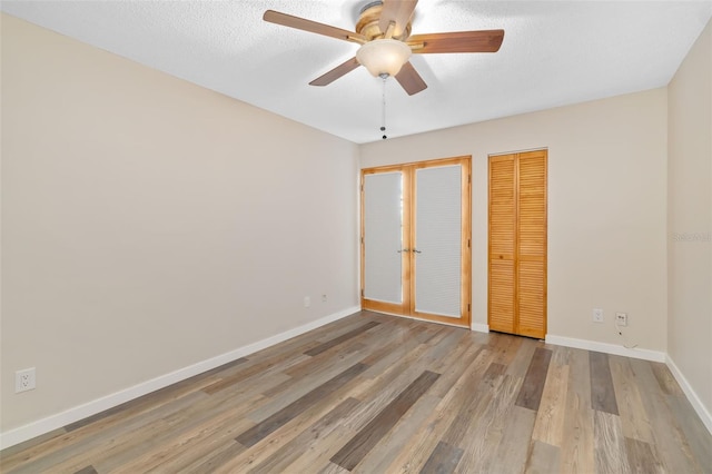 4885 1st St NE Unit 308, Saint Petersburg, FL 33703 - unfurnished bedroom with a closet, baseboards, a textured ceiling, a ceiling fan, and light wood finished floors