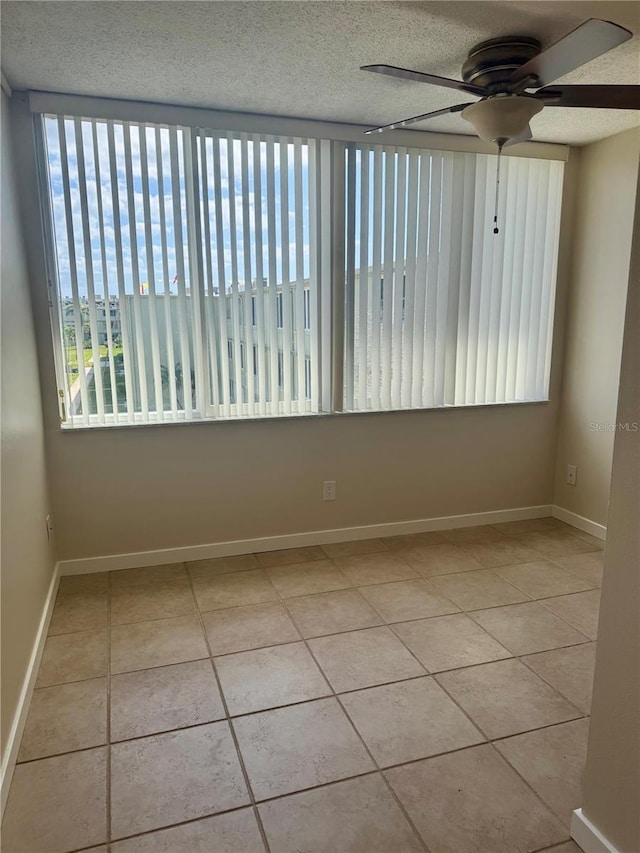 4885 1st St NE Unit 308, Saint Petersburg, FL 33703 - unfurnished room with ceiling fan, tile patterned flooring, baseboards, and a textured ceiling