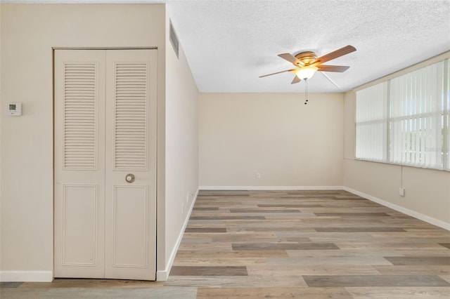 4885 1st St NE Unit 308, Saint Petersburg, FL 33703 - unfurnished bedroom with a closet, baseboards, light wood finished floors, and a textured ceiling