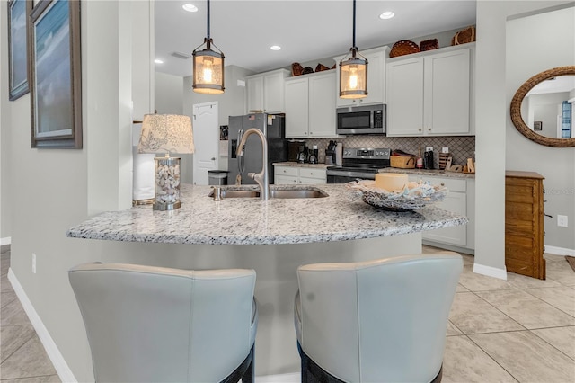 2918 130th Ave E, Parrish, FL 34219 - kitchen featuring appliances with stainless steel finishes, a peninsula, backsplash, white cabinets, and light stone counters