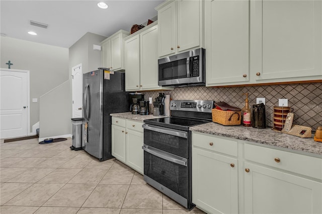 2918 130th Ave E, Parrish, FL 34219 - kitchen with stainless steel appliances, backsplash, light tile patterned flooring, light stone counters, and recessed lighting