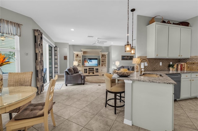 2918 130th Ave E, Parrish, FL 34219 - kitchen with dishwasher, light stone countertops, decorative backsplash, ceiling fan, and a peninsula