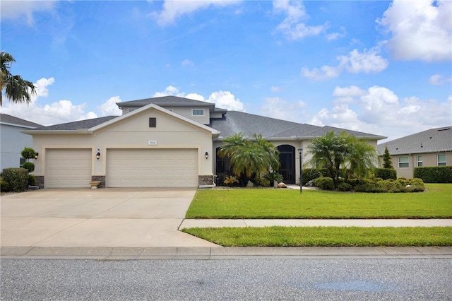 2918 130th Ave E, Parrish, FL 34219 - view of front facade featuring an attached garage, concrete driveway, stucco siding, a front yard, and stone siding