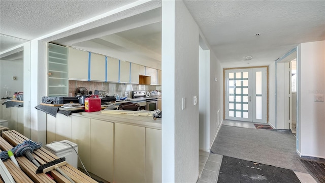 hall featuring light tile patterned flooring and a textured ceiling