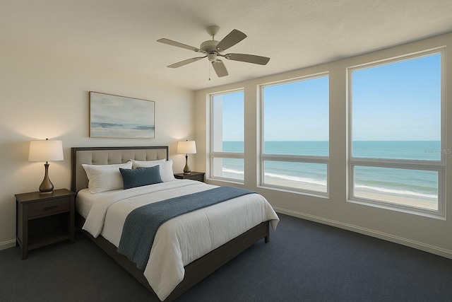 bedroom with dark colored carpet, baseboards, a ceiling fan, and a water view