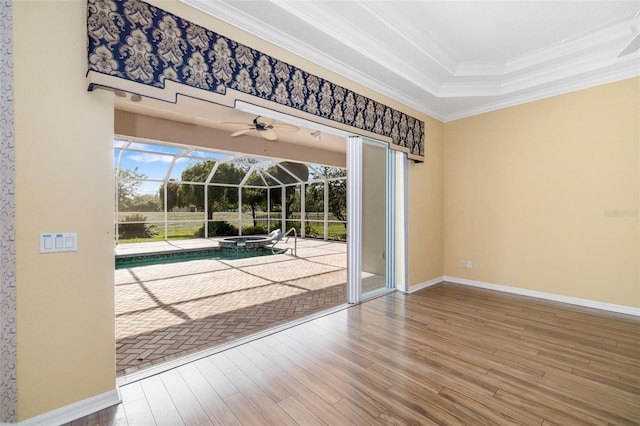 244 Dove Trl, Bradenton, FL 34212 - doorway to outside featuring a sunroom, wood finished floors, ceiling fan, ornamental molding, and a tray ceiling