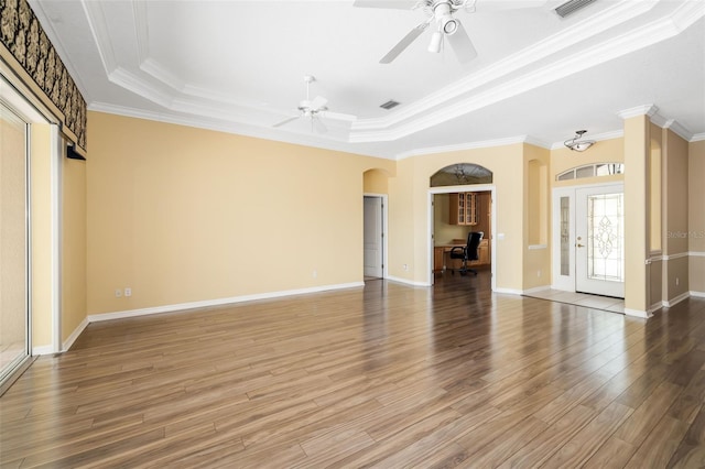 244 Dove Trl, Bradenton, FL 34212 - unfurnished living room featuring a raised ceiling, arched walkways, a ceiling fan, wood finished floors, and ornamental molding