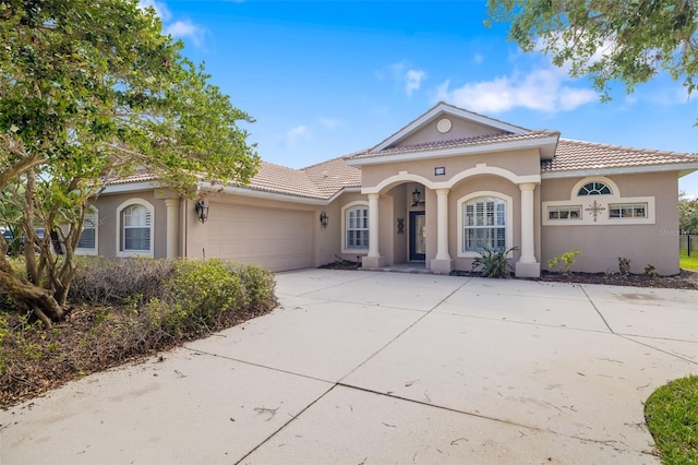 244 Dove Trl, Bradenton, FL 34212 - mediterranean / spanish house with an attached garage, a tile roof, concrete driveway, and stucco siding
