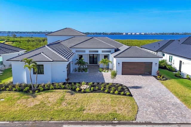 1613 4th St E, Palmetto, FL 34221 - view of front facade with an attached garage, french doors, a tiled roof, a front yard, and stucco siding