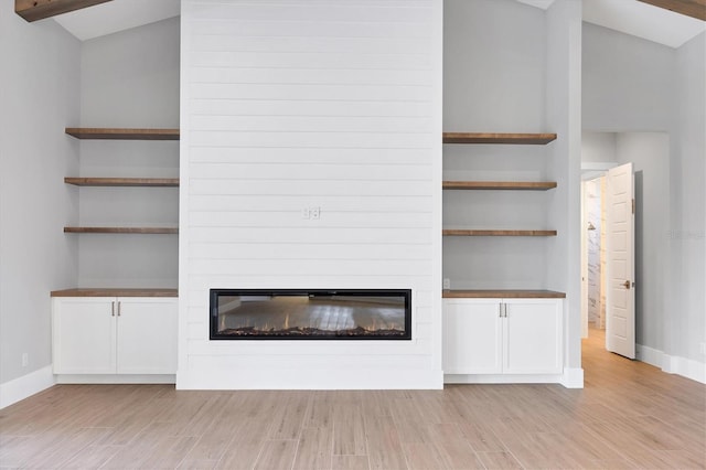 1613 4th St E, Palmetto, FL 34221 - unfurnished living room featuring a fireplace, light wood-style flooring, and baseboards
