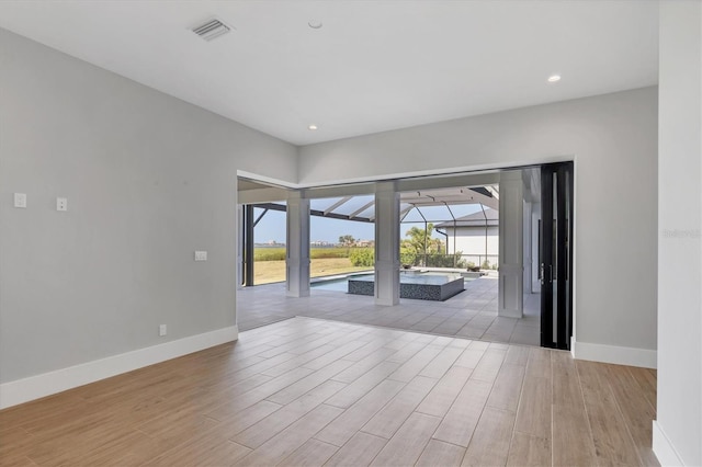 1613 4th St E, Palmetto, FL 34221 - unfurnished room with baseboards, light wood finished floors, and recessed lighting