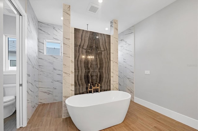 1613 4th St E, Palmetto, FL 34221 - full bathroom with a soaking tub, toilet, recessed lighting, tile walls, and a marble finish shower