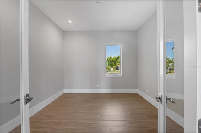 1613 4th St E, Palmetto, FL 34221 - empty room with french doors, wood finished floors, baseboards, and recessed lighting
