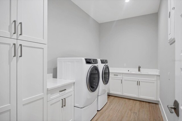 1613 4th St E, Palmetto, FL 34221 - washroom featuring cabinet space, independent washer and dryer, and light wood-type flooring