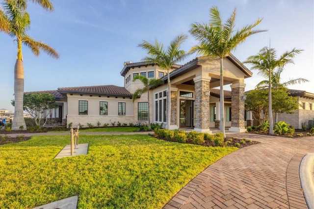 1613 4th St E, Palmetto, FL 34221 - rear view of property with stone siding, a yard, stucco siding, and a tile roof