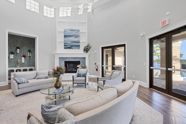 1613 4th St E, Palmetto, FL 34221 - living room featuring french doors, a towering ceiling, wood finished floors, baseboards, and a glass covered fireplace