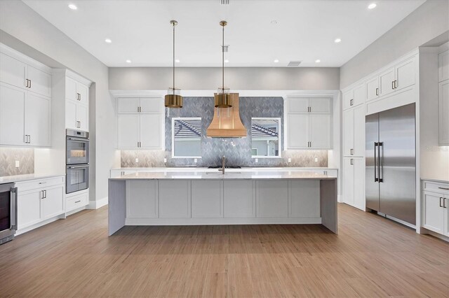 1613 4th St E, Palmetto, FL 34221 - kitchen featuring stainless steel appliances, custom range hood, light countertops, and recessed lighting