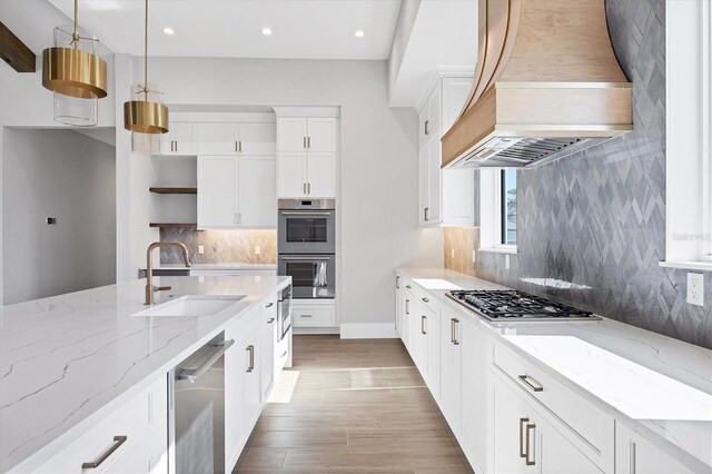 1613 4th St E, Palmetto, FL 34221 - kitchen featuring premium range hood, open shelves, a sink, appliances with stainless steel finishes, and decorative backsplash