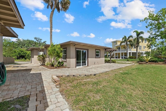 6718 68th Ave E, Bradenton, FL 34203 - rear view of house featuring a yard, a patio, and stucco siding
