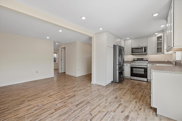 6718 68th Ave E, Bradenton, FL 34203 - kitchen featuring open floor plan, light wood-style floors, a sink, and appliances with stainless steel finishes