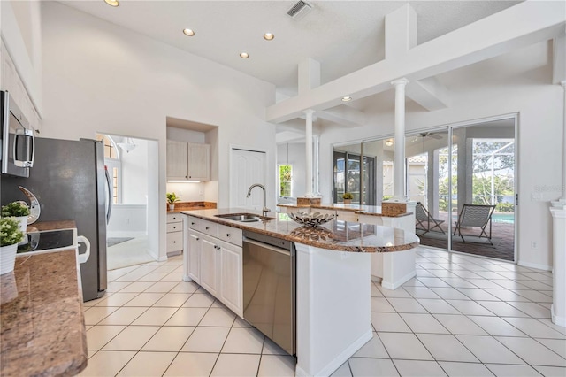 8824 Havenridge Dr, Sarasota, FL 34238 - kitchen with light tile patterned floors, light stone countertops, ornate columns, stainless steel appliances, and a sink